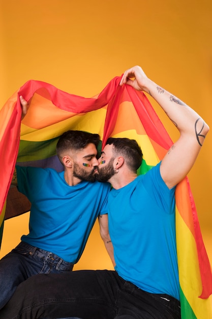 Giovani che si baciano sotto la bandiera LGBT