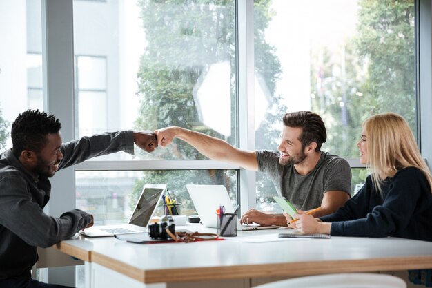 Giovani colleghi sorridenti che si siedono nel coworking dell'ufficio