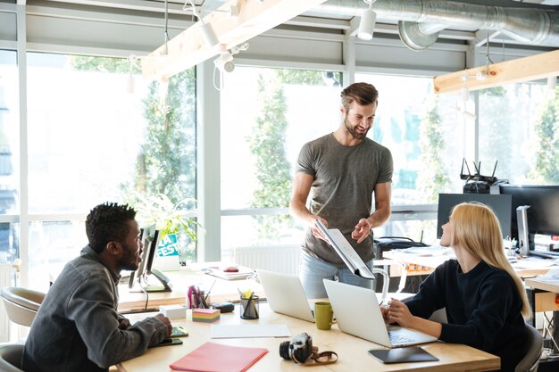 Giovani colleghi sorridenti che si siedono nel coworking dell'ufficio