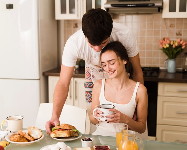 Giovani coppie adorabili insieme per la prima colazione