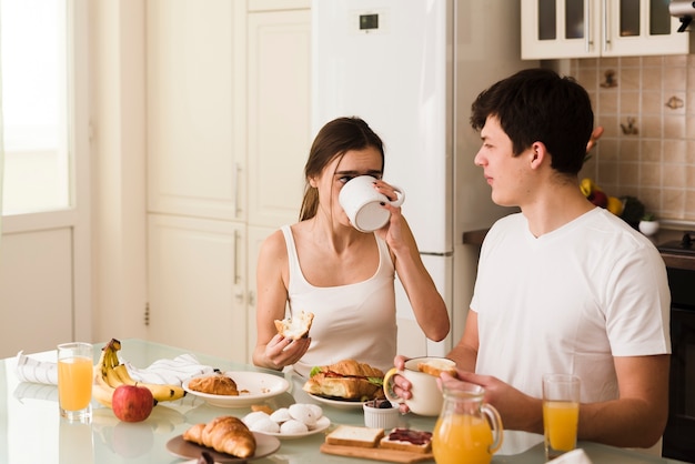 Giovani coppie adorabili insieme per la prima colazione