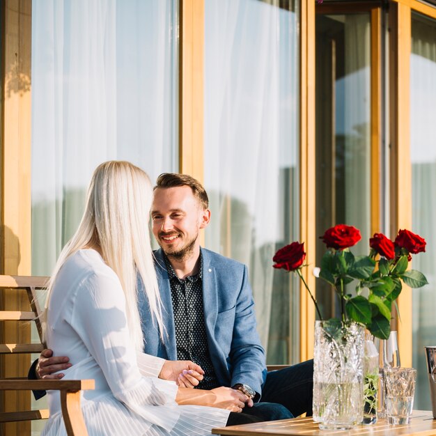 Giovani coppie adorabili romantiche che si siedono nel ristorante