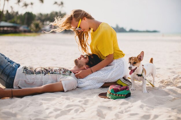 Giovani coppie alla moda hipster nell'amore sulla spiaggia tropicale durante le vacanze