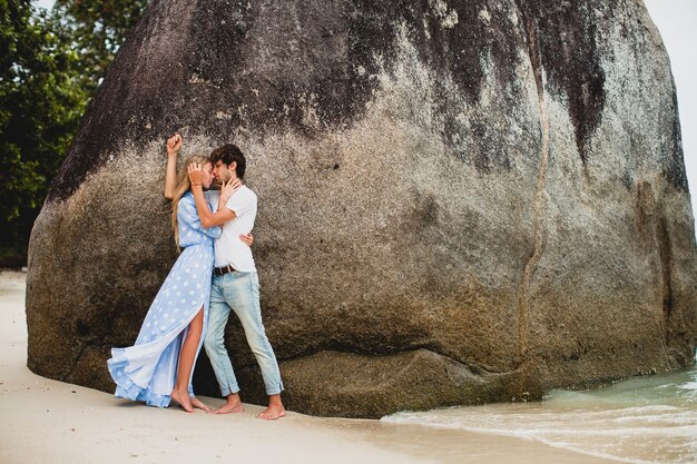 Giovani coppie alla moda hipster nell'amore sulla spiaggia tropicale durante le vacanze