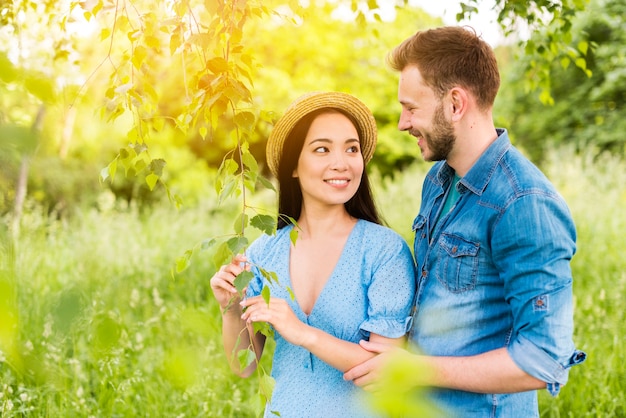 Giovani coppie allegre che sorridono a vicenda con amore in natura