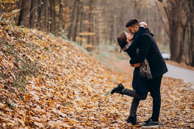 Giovani coppie che camminano insieme in un parco in autunno