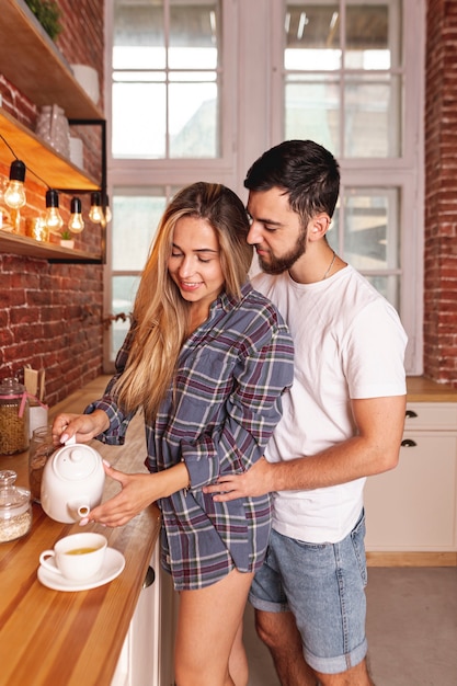 Giovani coppie che catturano prima colazione alla cucina