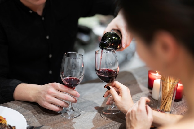 Giovani coppie che celebrano il giorno di san valentino mentre pranzano e bevono vino insieme