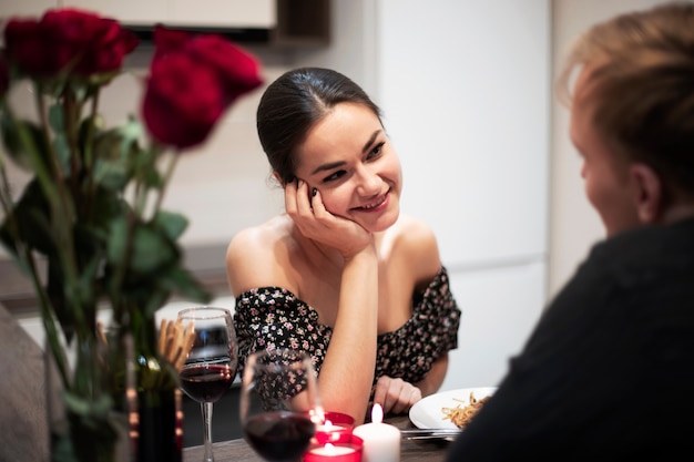 Giovani coppie che celebrano il giorno di san valentino mentre pranzano e bevono vino insieme