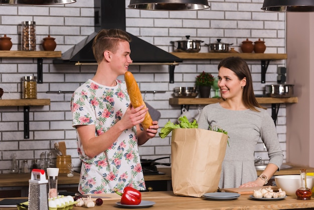 Giovani coppie che preparano gli ingredienti per cucinare