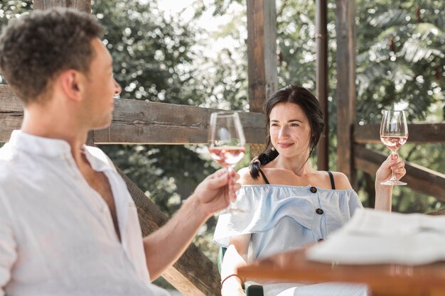 Giovani coppie che se lo esaminano che alza pane tostato di vino