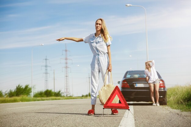 Giovani coppie che vanno in viaggio di vacanza in macchina in una giornata di sole