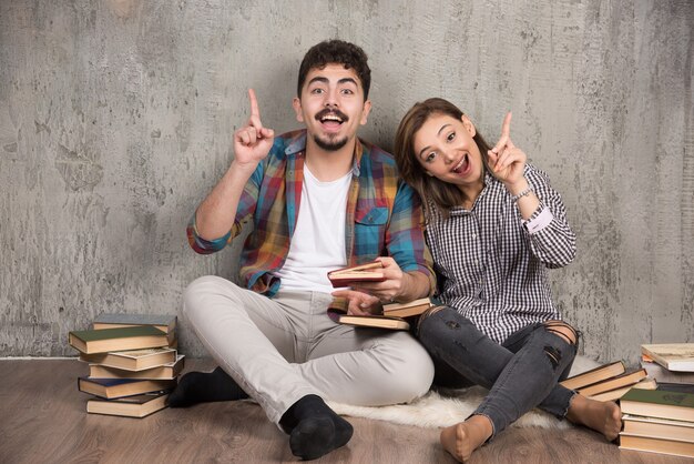 Giovani coppie con un libro interessante che punta al rialzo