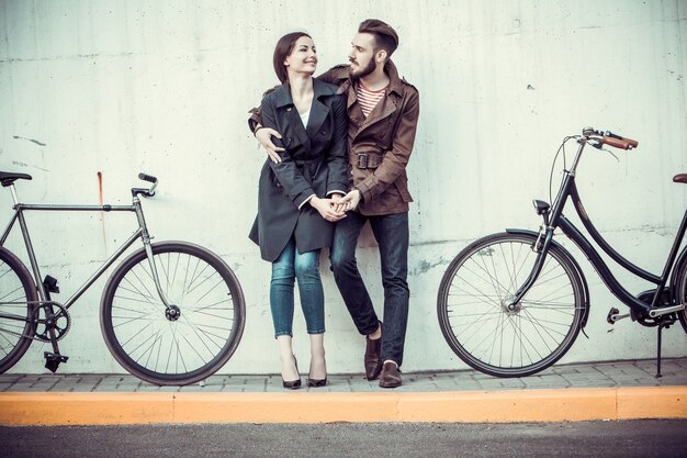Giovani coppie con una bicicletta di fronte alla città