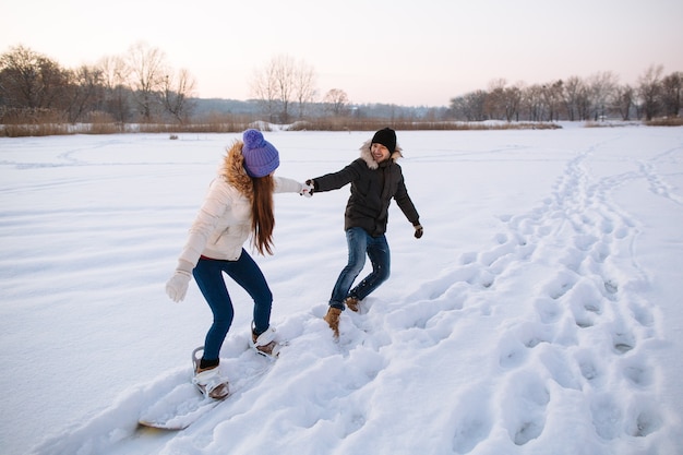 Giovani coppie felici divertendosi nella stazione sciistica un giorno di inverno nevoso.