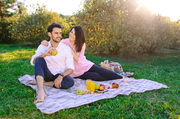 Giovani coppie nel parco all'aperto che ha un picnic