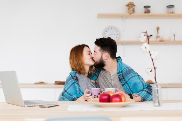 Giovani coppie romantiche che baciano nella cucina