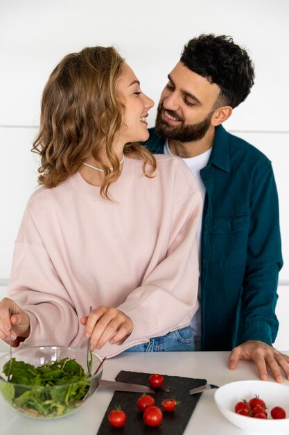 Giovani coppie romantiche che cucinano insieme a casa