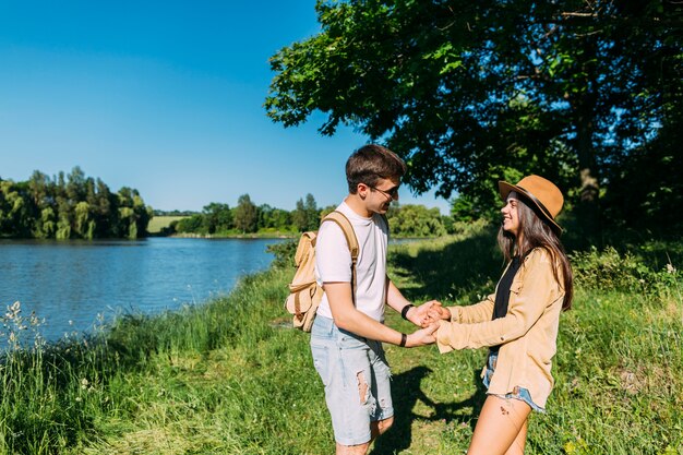 Giovani coppie romantiche che godono all&#39;aperto vicino al lago