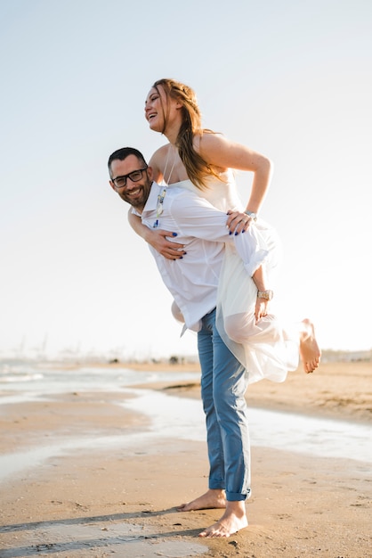 Giovani coppie romantiche che godono delle vacanze estive sulla spiaggia