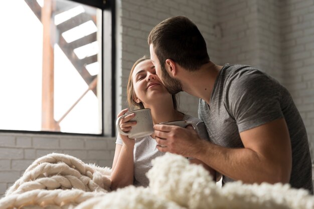 Giovani coppie romantiche che mangiano caffè a letto