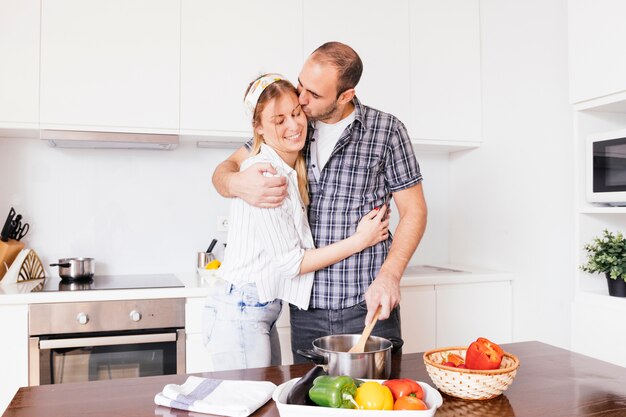 Giovani coppie romantiche che preparano il cibo in cucina