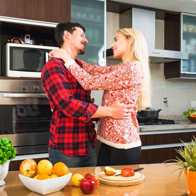 Giovani coppie romantiche che se lo esaminano nella cucina