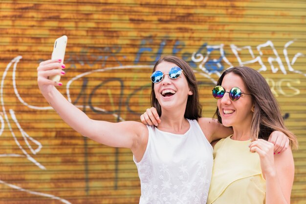 Giovani donne che assumono selfie su smartphone