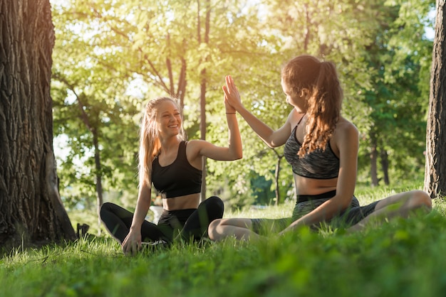 Giovani donne che fanno yoga nel parco