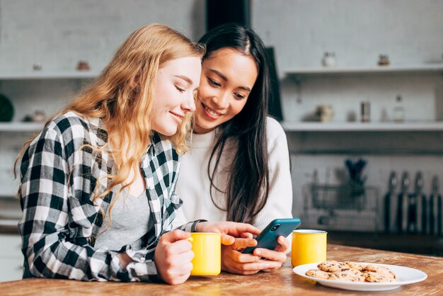 Giovani donne che praticano il surfing in smartphone