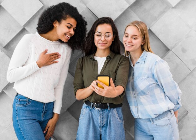 Giovani donne di smiley che prendono selfie