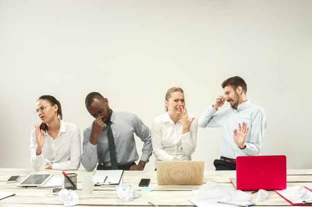 Giovani e donne che si siedono all'ufficio e che lavorano ai computer portatili. Concetto di emozioni