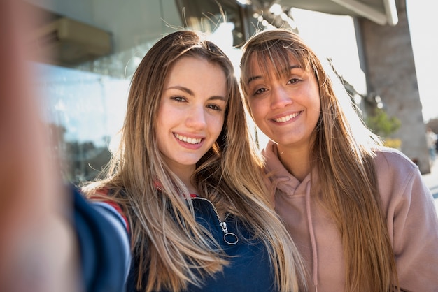 Giovani femmine di smiley che prendono selfie