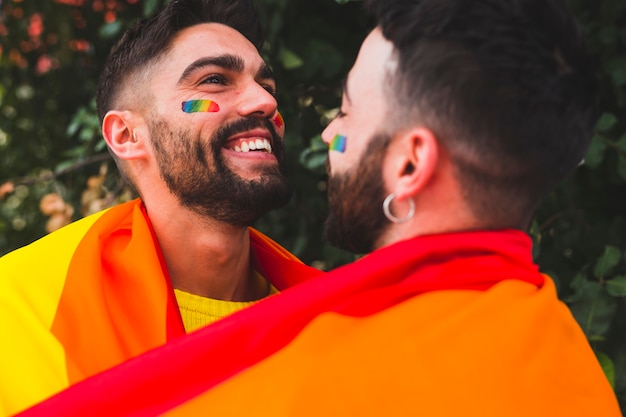 Giovani gay sorridenti e abbracci in strada