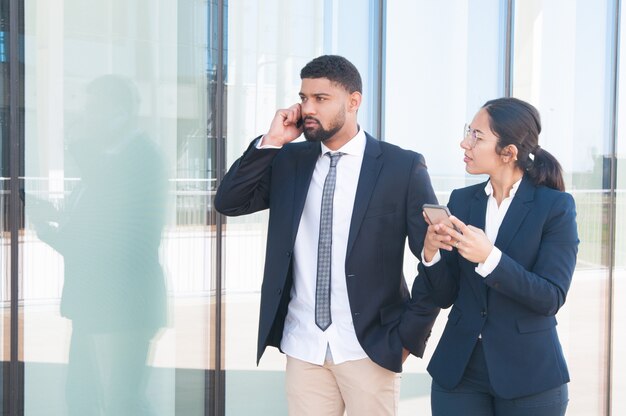 Giovani imprenditori di successo che utilizzano gli smartphone