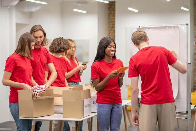 Giovani in rosso che sembrano occupati mentre lavorano con la distribuzione di donazioni