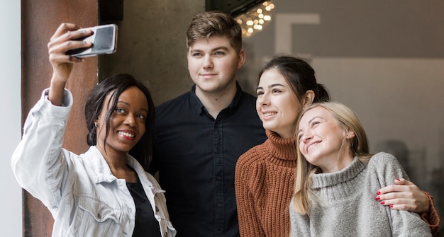 Giovani positivi che prendono insieme un selfie