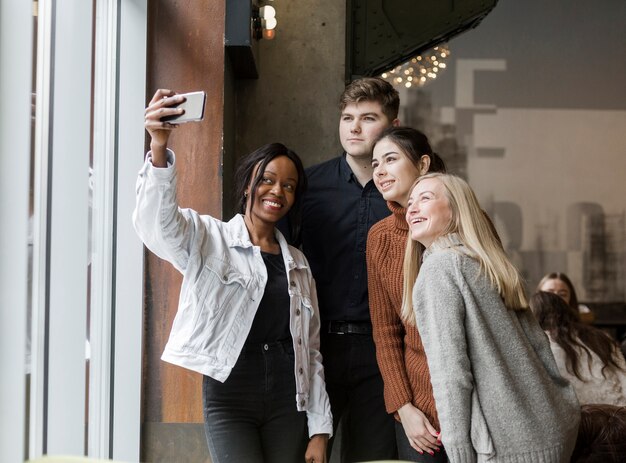 Giovani positivi che prendono insieme un selfie