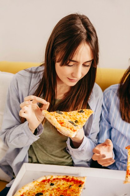 Giovani ragazze che mangiano pizza