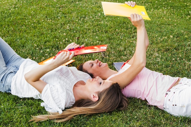 Giovani ragazze che presentano con blocchi note