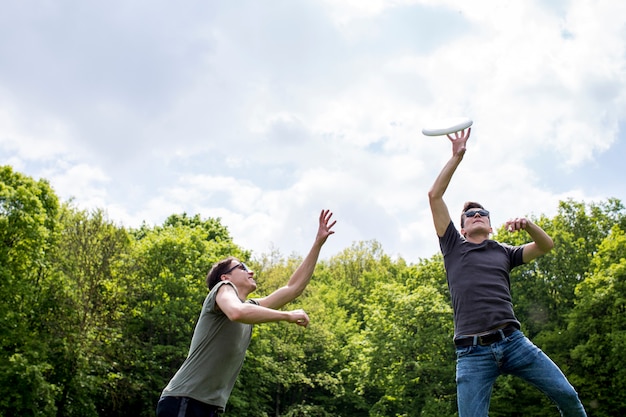 Giovani ragazzi che giocano a frisbee in natura