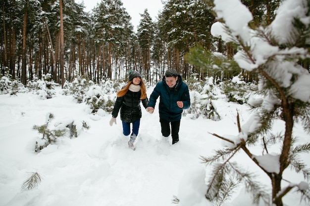 Giovani ragazzi divertirsi nella foresta in inverno nevoso.