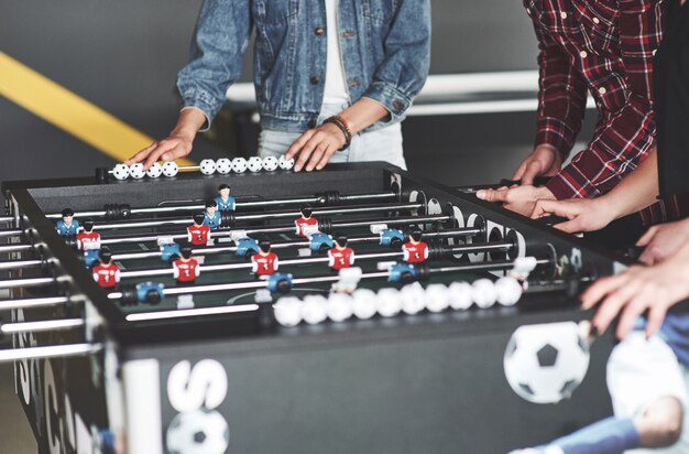 Giovani sorridenti che giocano a calcio-balilla mentre in vacanza