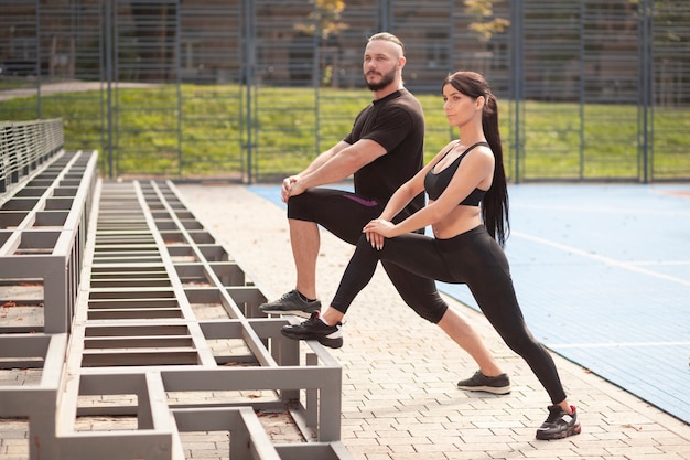 Giovani sportivi all'esercizio delle gambe dello stadio