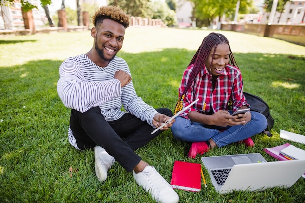 Giovani studenti che studiano sul prato