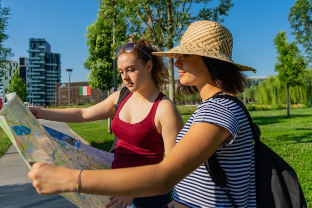 Giovani turiste caucasiche che guardano la mappa della città