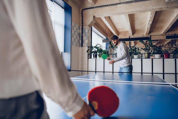 Giovani uomini e donne che giocano a ping pong