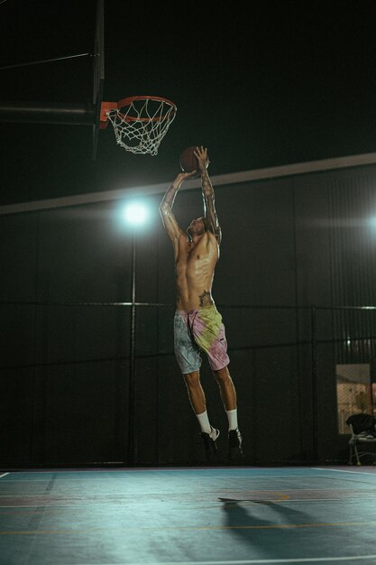 Gli amici giocano a basket. I giovani giocano a basket per strada.