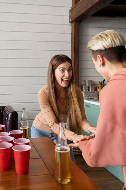 Gli amici si danno il cinque e si emozionano davanti a una partita a beer pong