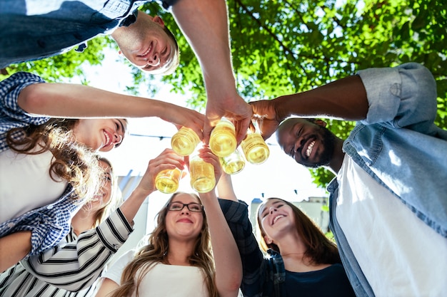 Gli amici sorrisi festeggiano il compleanno all'aria aperta in una calda giornata di sole estivo